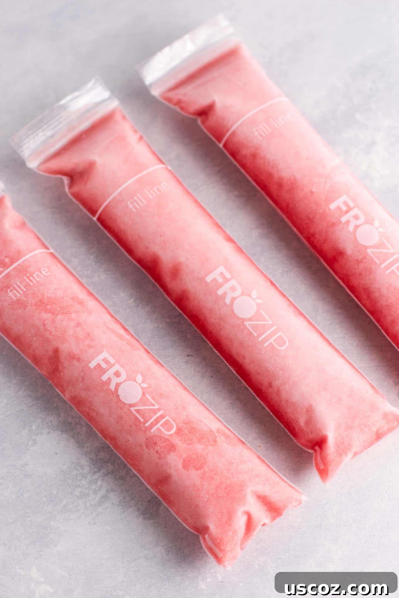 A beautifully composed shot of multiple Strawberry Pineapple Freezer Pops, artfully arranged, promising a delicious and healthy frozen treat for all ages.