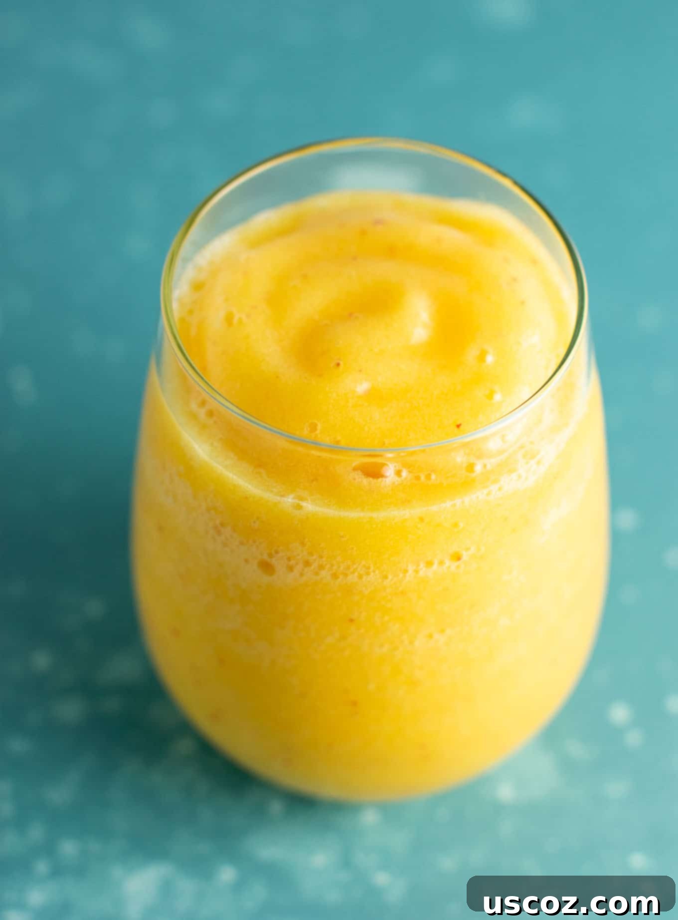 A vibrant peach moscato slushie in a stemmed glass, showcasing the perfect summer drink for a refreshing experience.