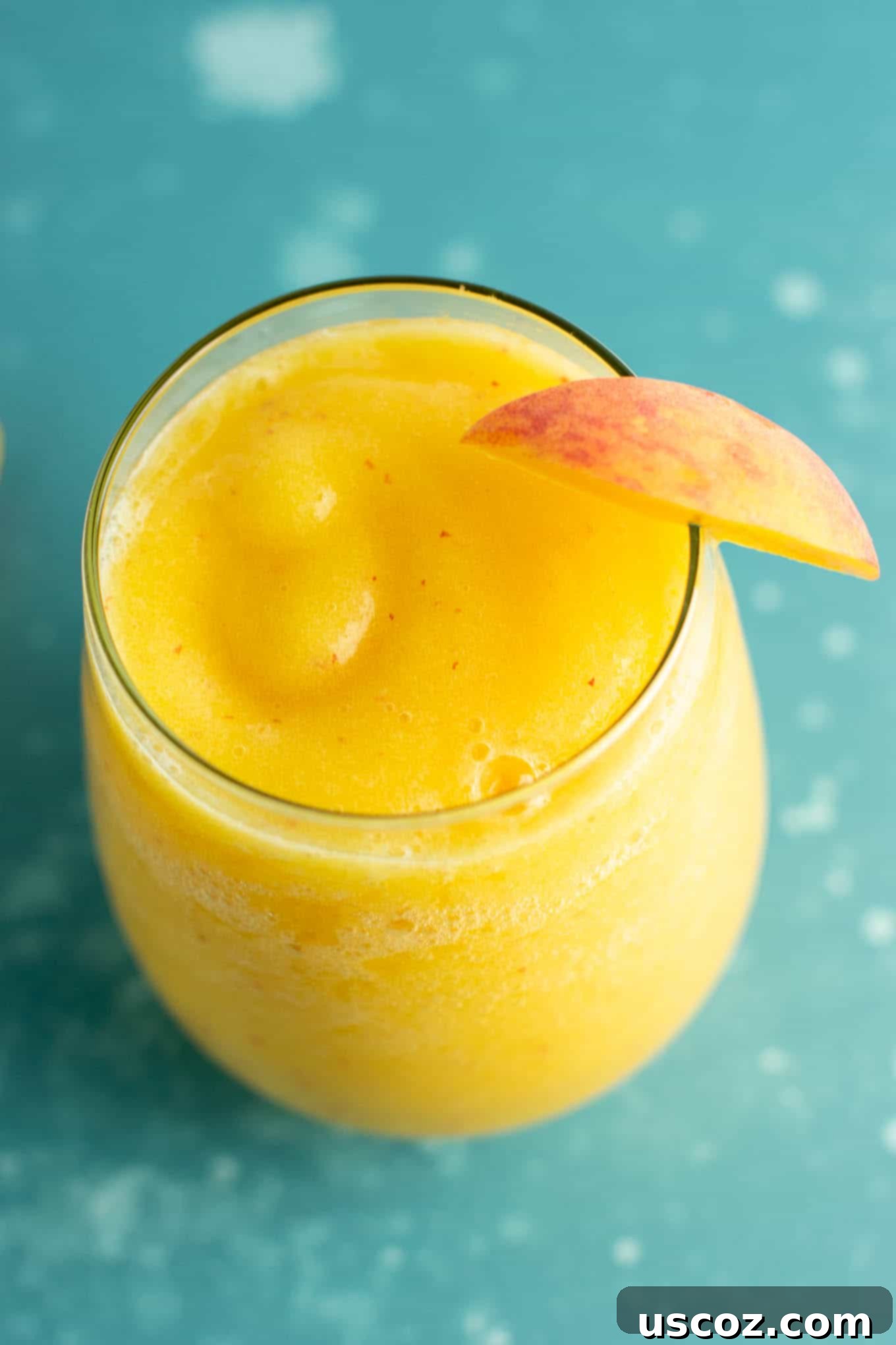 A close-up of a perfectly blended peach moscato slushie in a glass, ready to be enjoyed as a refreshing summer drink.