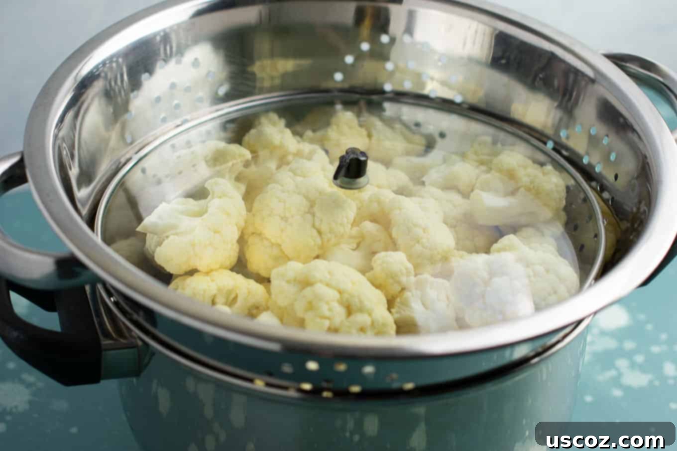 Perfectly Steamed Cauliflower 7 The steaming setup with the lid off, showing the water level in the pot beneath the colander of cauliflower florets, emphasizing the need to check water.