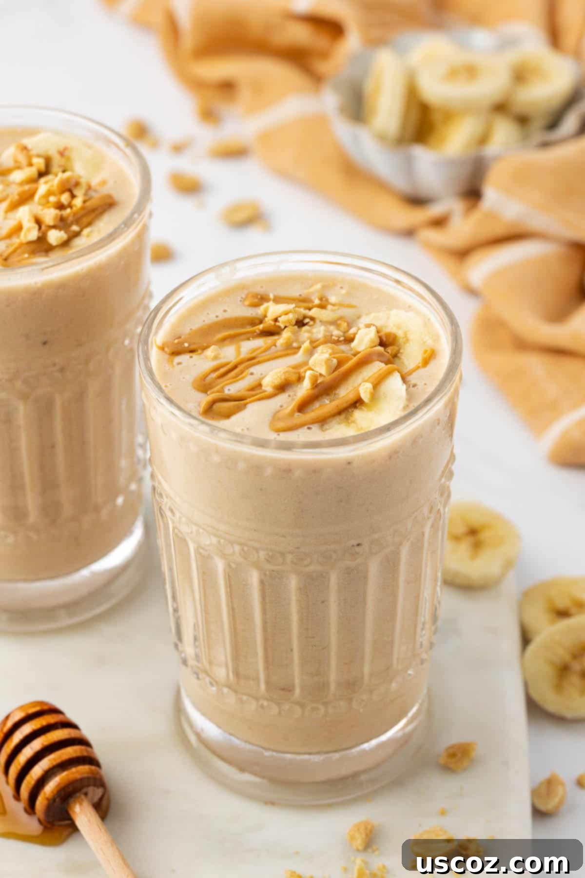 Peanut Butter Banana Dream 2 peanut butter banana smoothie topped with drizzled peanut butter and peanuts