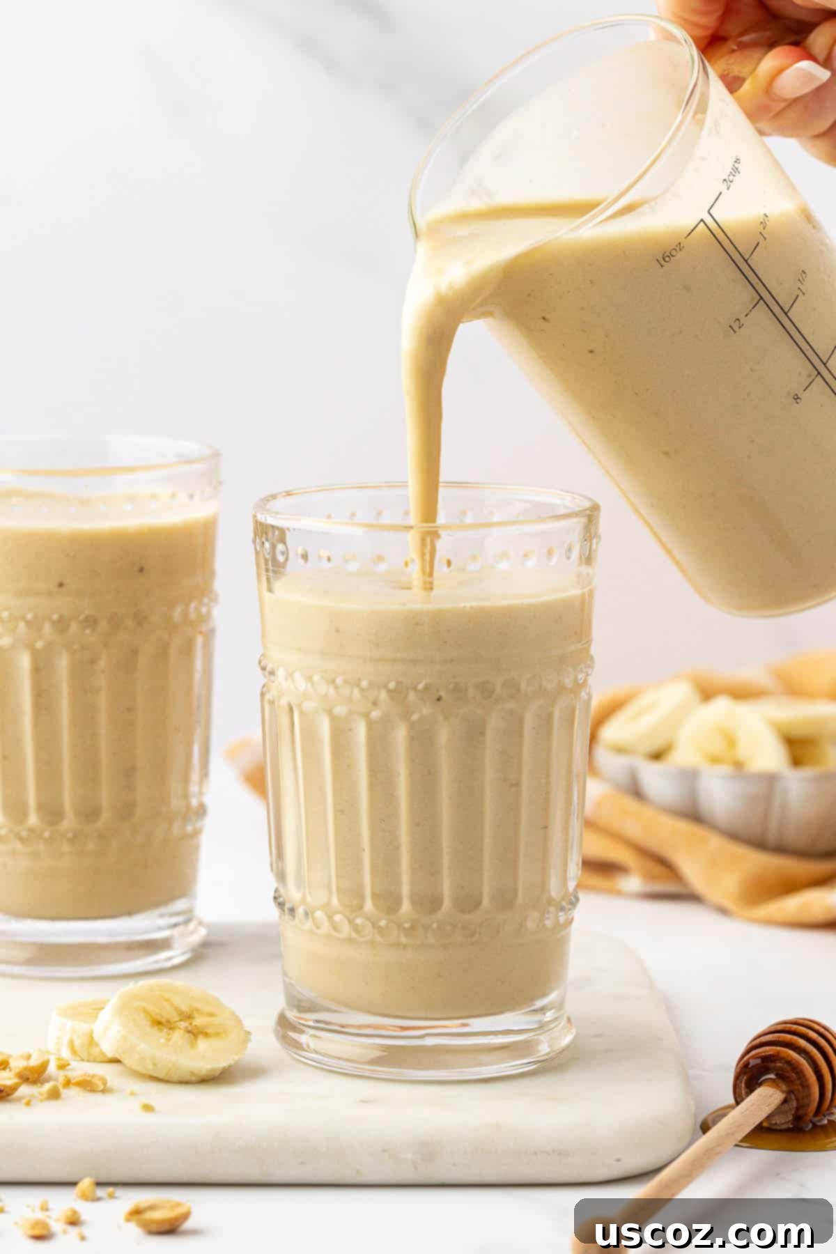 Peanut Butter Banana Dream 4 pouring a smoothie into a glass cup