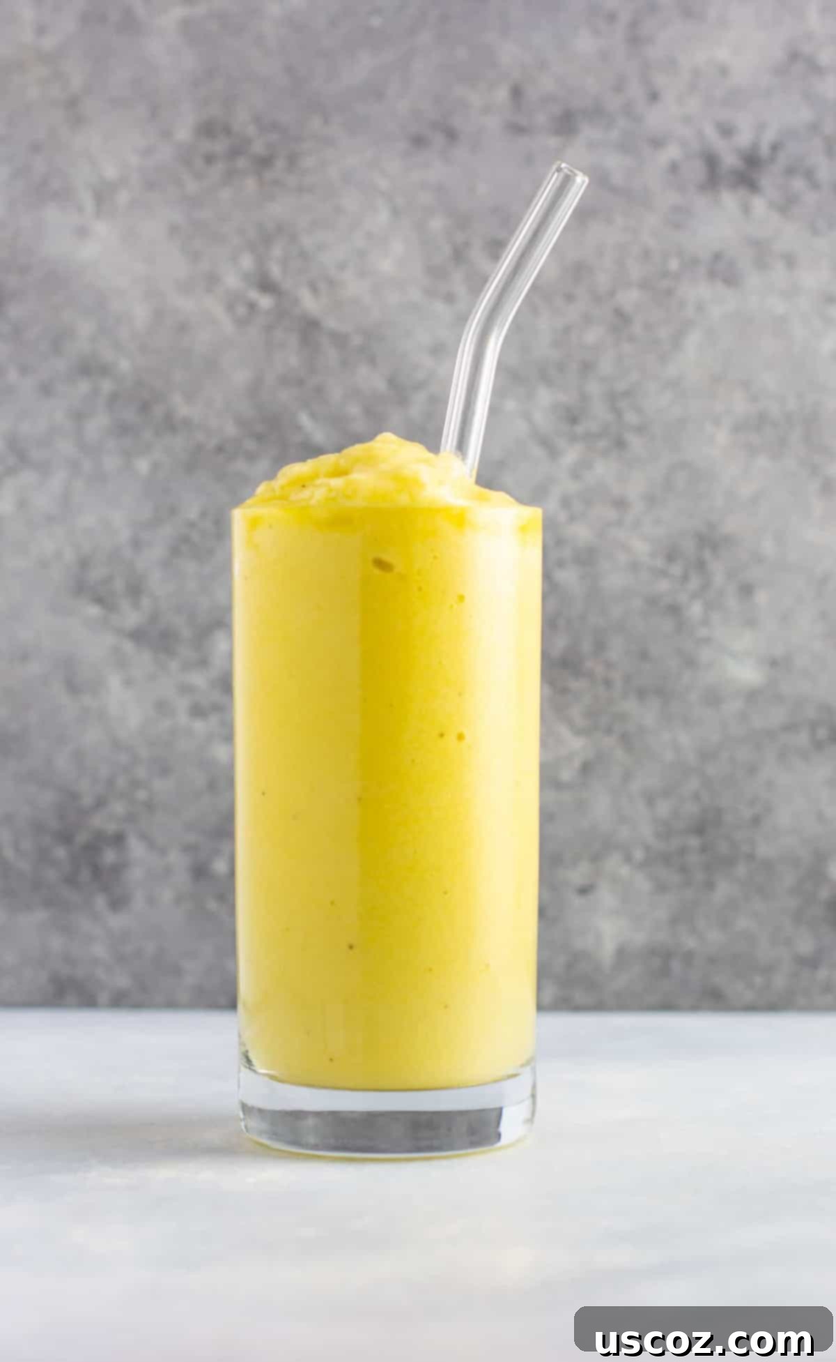 Pineapple Detox Blast 2 Vibrant pineapple detox smoothie with fresh cucumbers, celery, bright lemon slices, sweet peaches, zesty ginger, and creamy frozen bananas, presented in a glass for a healthy and delicious vegan treat.