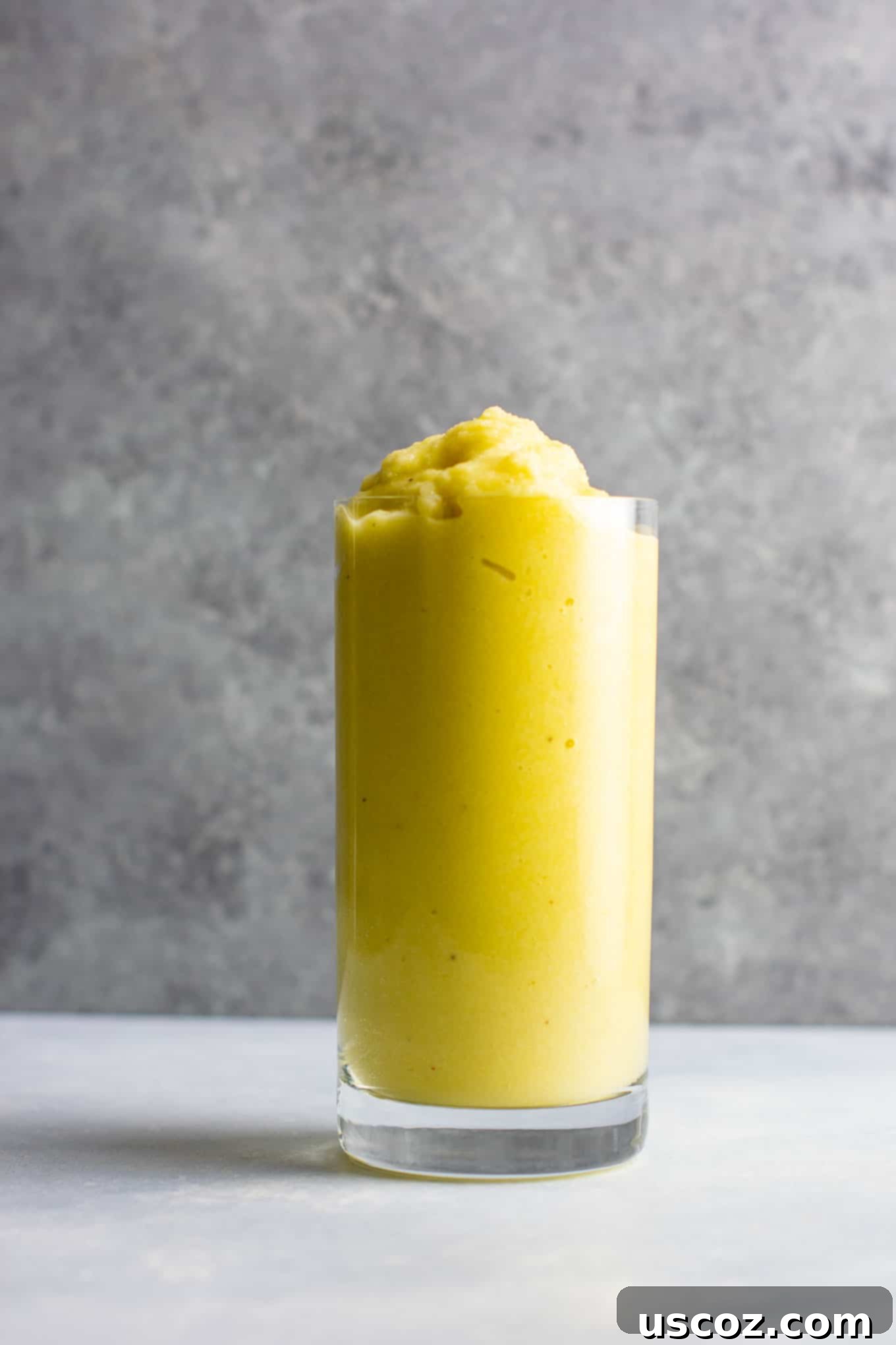 Pineapple Detox Blast 11 Ingredients for a pineapple detox smoothie including a whole pineapple, cucumber, celery, lemon, and ginger, arranged artfully on a white surface.