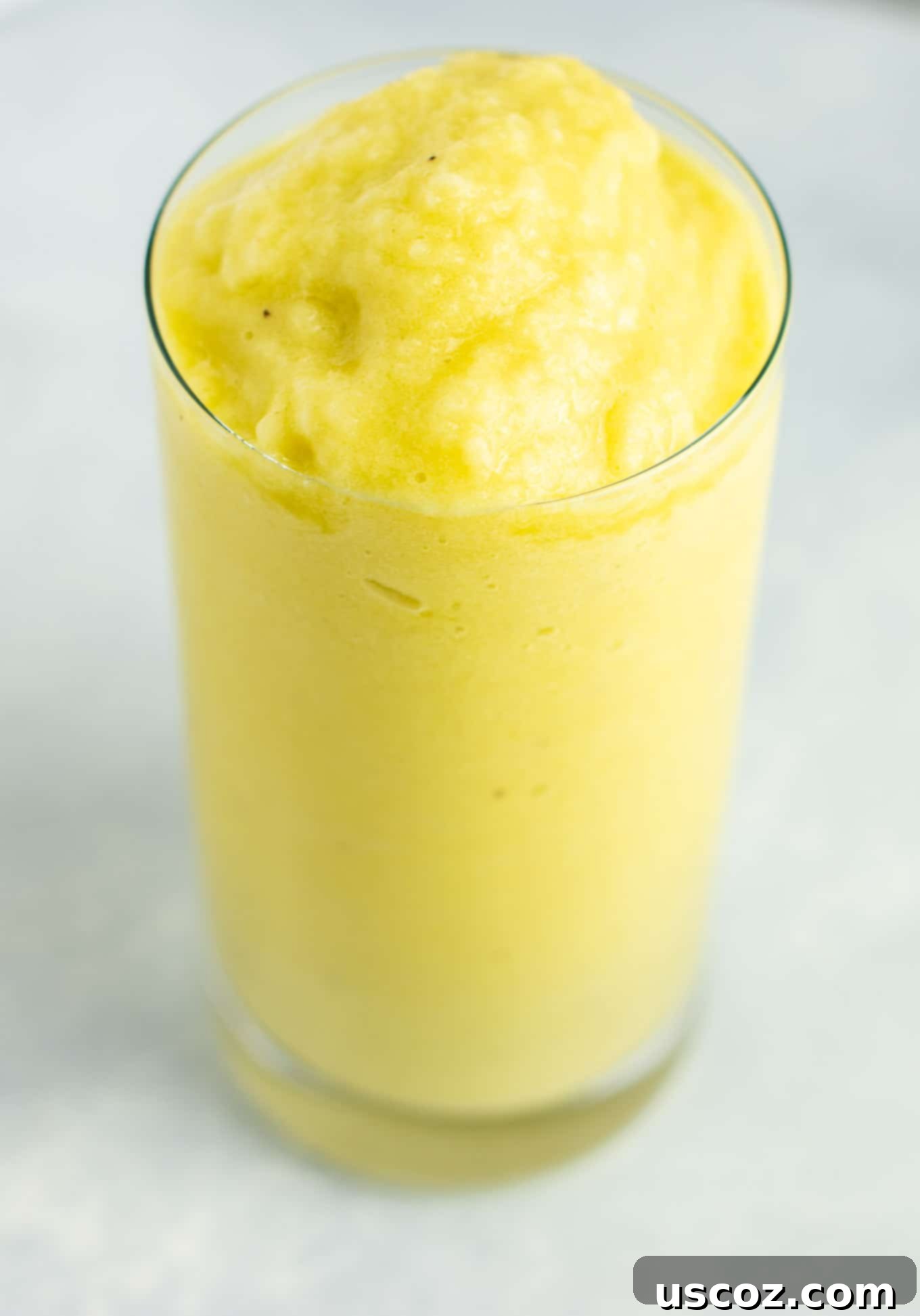 Pineapple Detox Blast 12 A refreshing pineapple detox smoothie in a glass, garnished with a slice of pineapple, ready to be enjoyed as a healthy vegan drink.