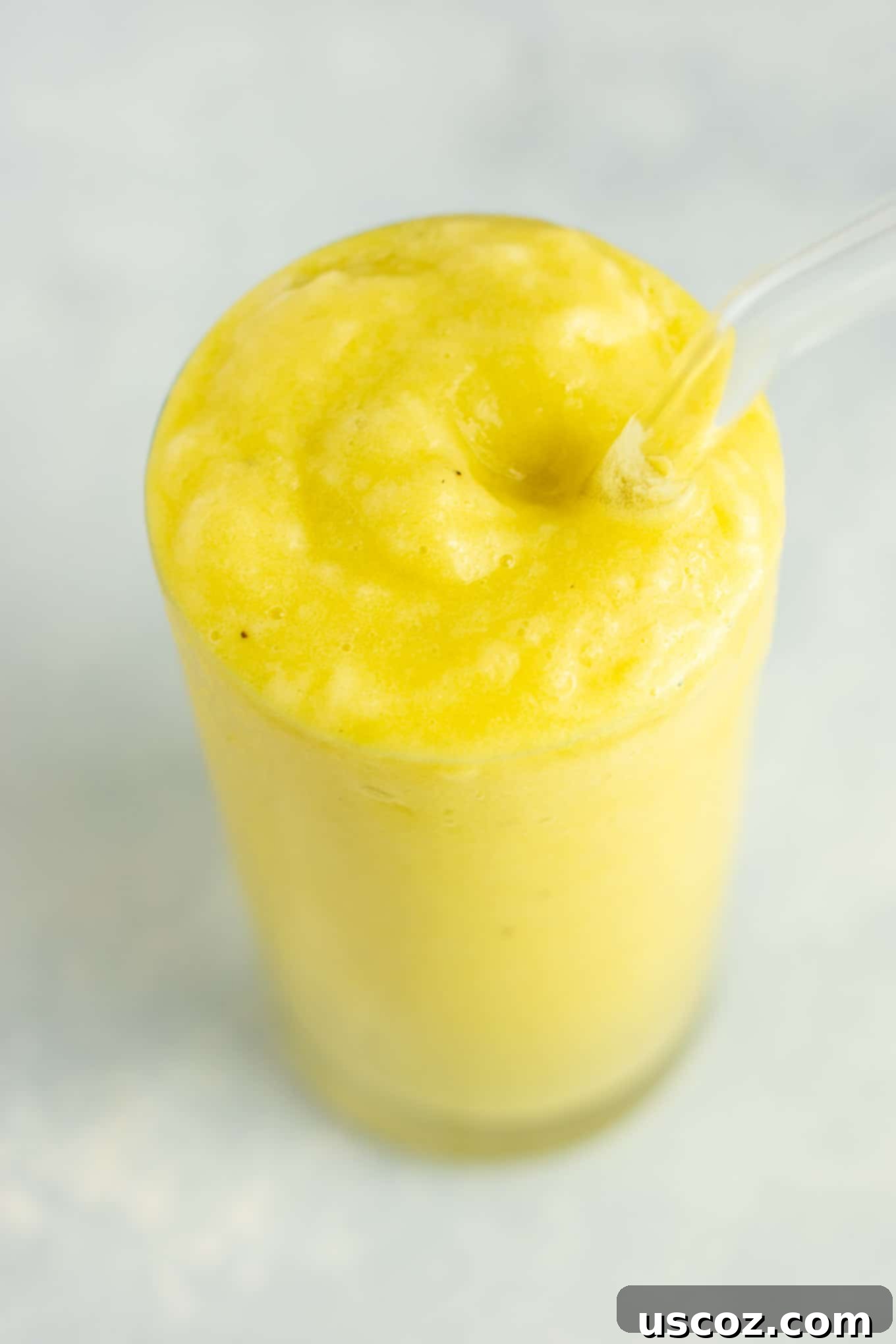 Pineapple Detox Blast 14 An aerial view of a vibrant pineapple detox smoothie in a glass, surrounded by fresh ingredients like pineapple, cucumber, and lemon.