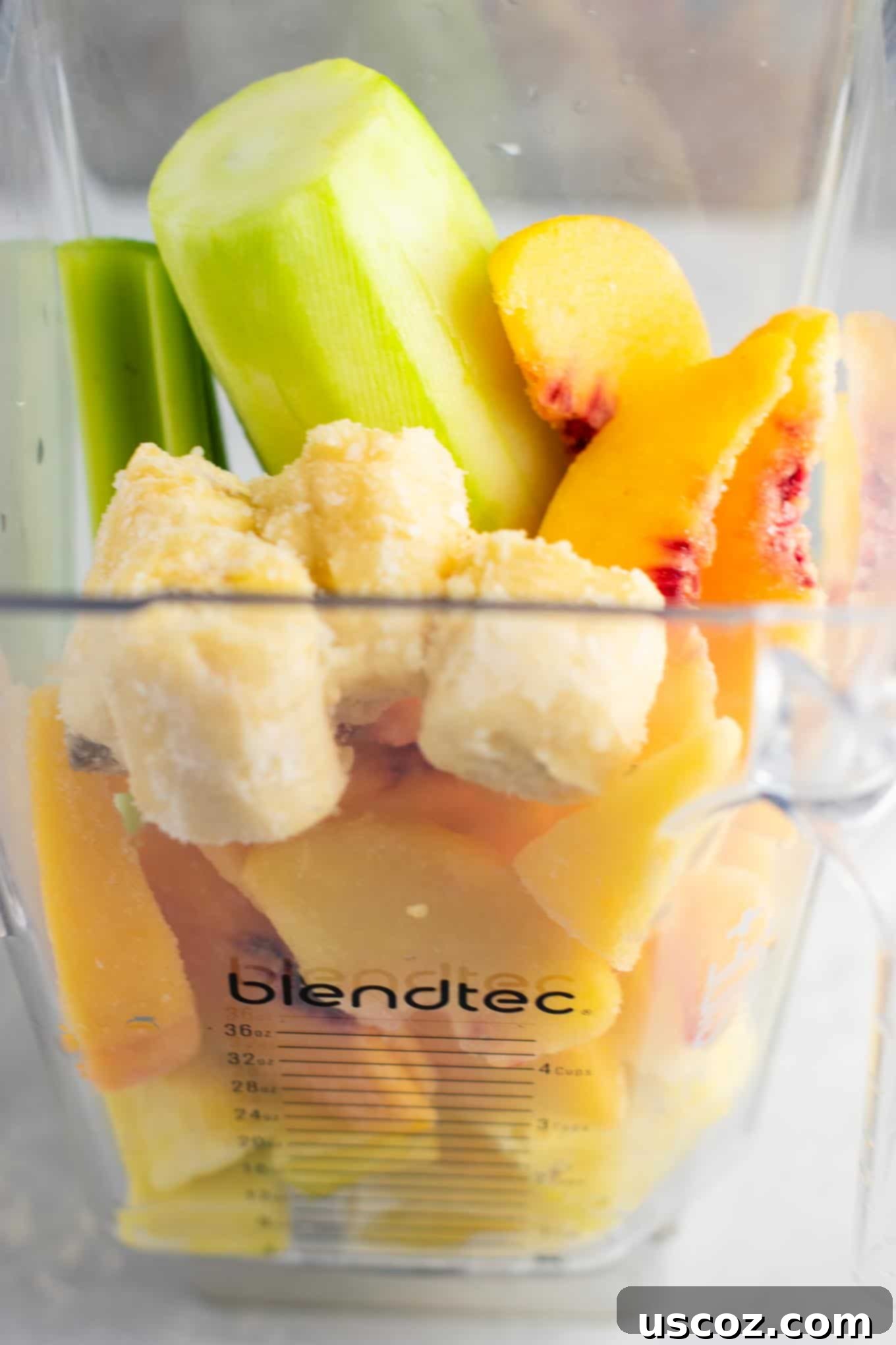 Pineapple Detox Blast 3 Close-up of a refreshing pineapple detox smoothie in a glass with a straw, showcasing its thick and creamy texture.