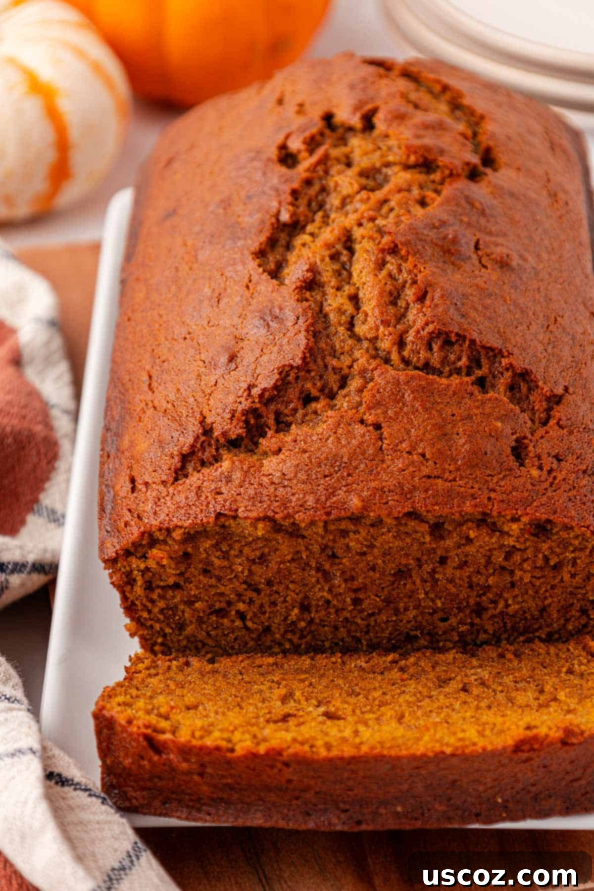 A perfect pumpkin bread, cooled and ready to be sliced, on a wire rack