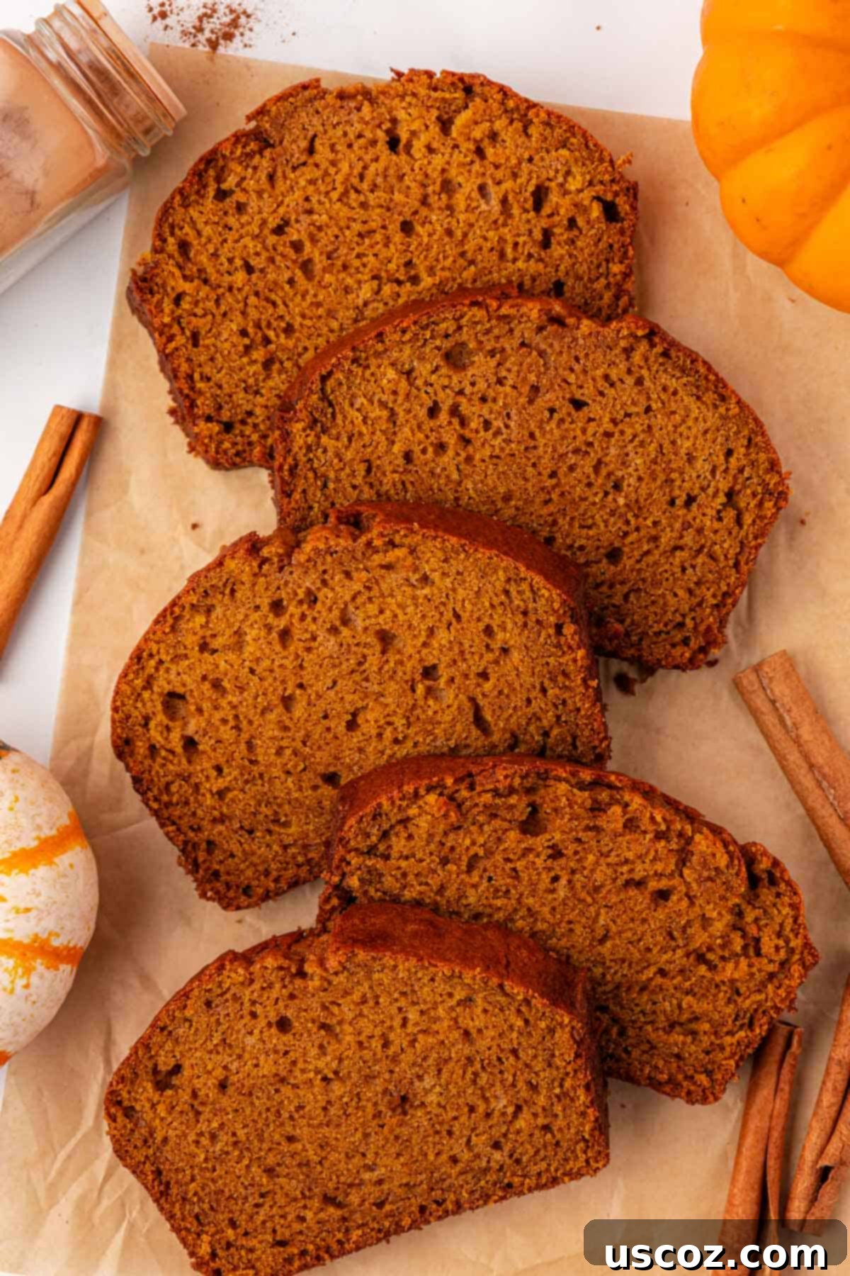 Multiple slices of moist pumpkin bread arranged artfully on a serving platter