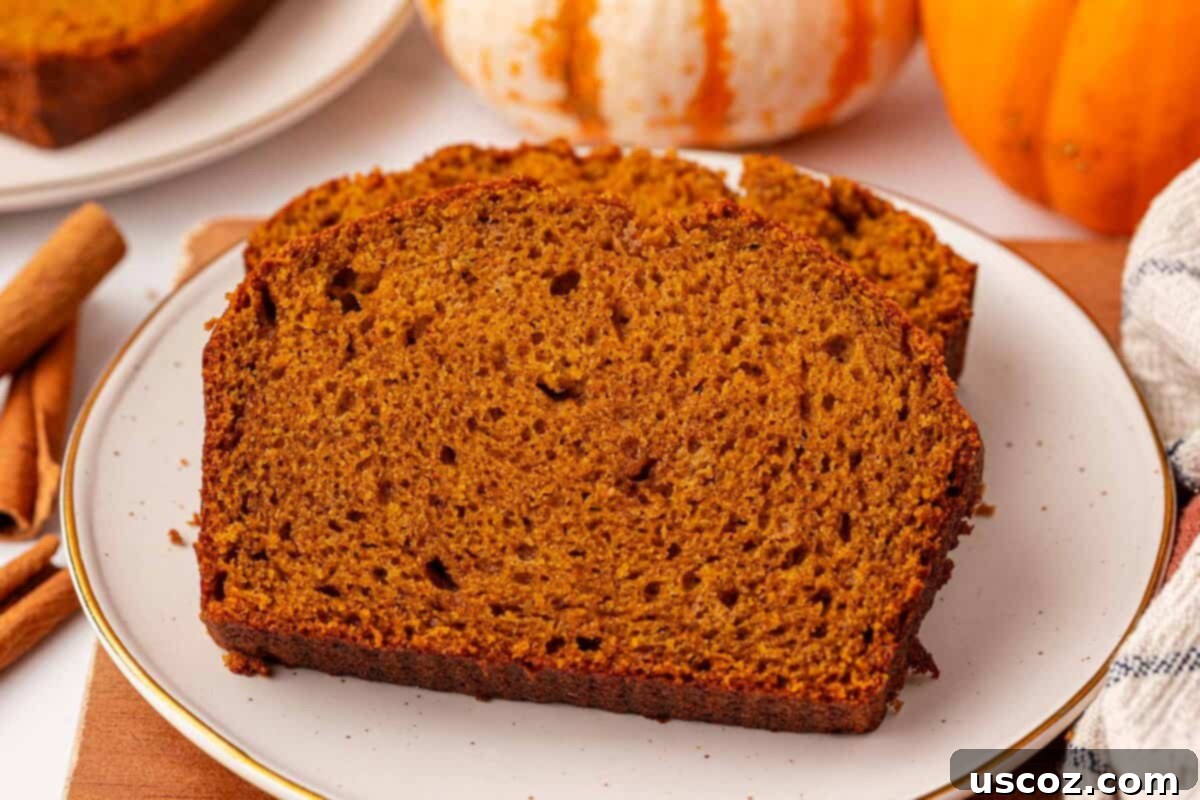 A close-up of a beautifully sliced pumpkin bread showing its moist interior and perfect texture