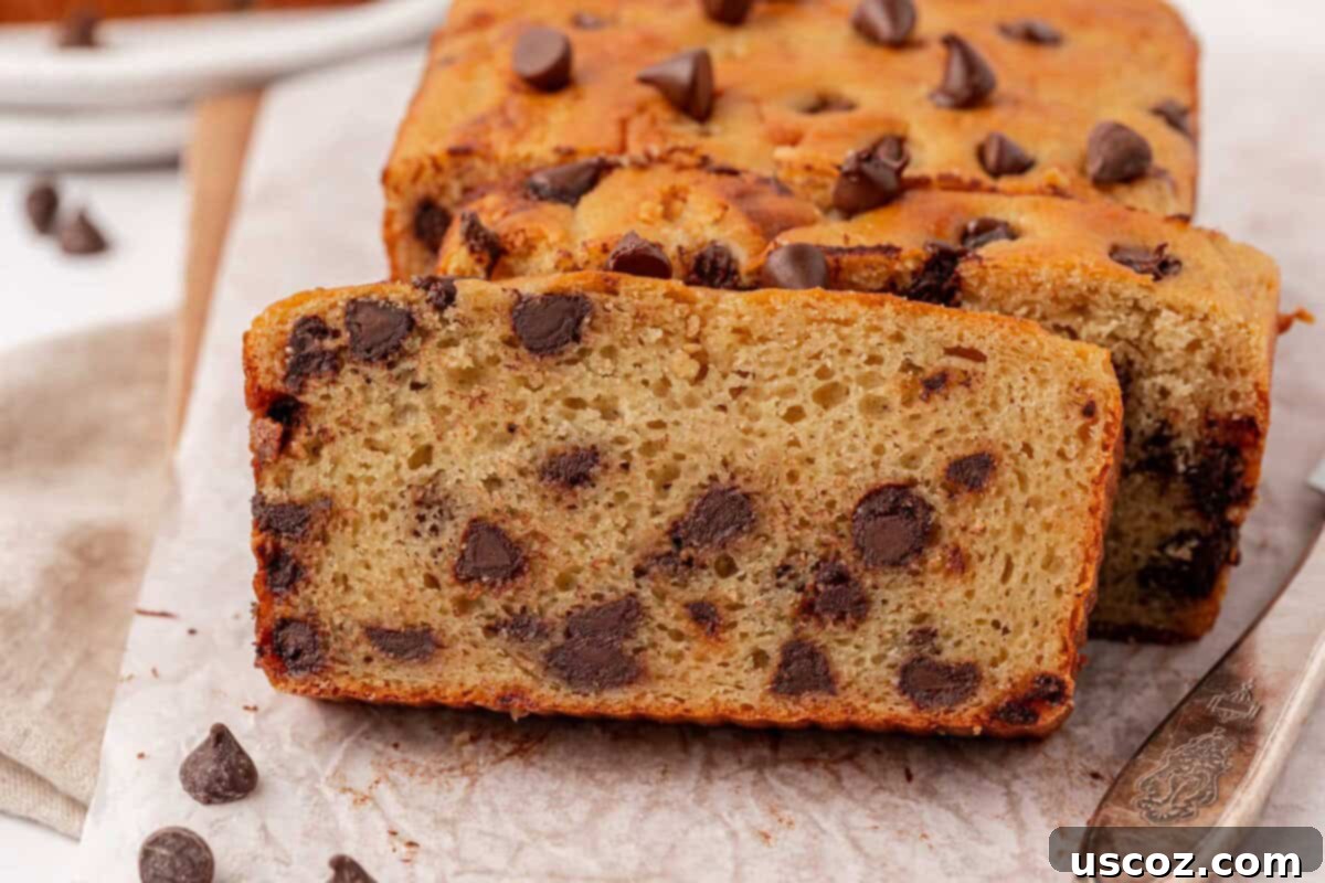 A beautifully presented loaf of Greek yogurt chocolate chip quick bread with a few slices cut
