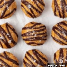 Peanut butter crunch energy bites drizzled generously with rich dark chocolate, resembling peanut butter cups