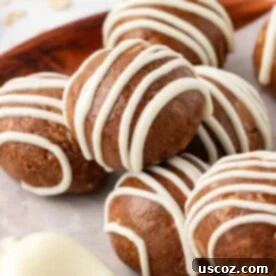 Swirled cinnamon roll energy bites with a creamy white glaze, reminiscent of a classic pastry