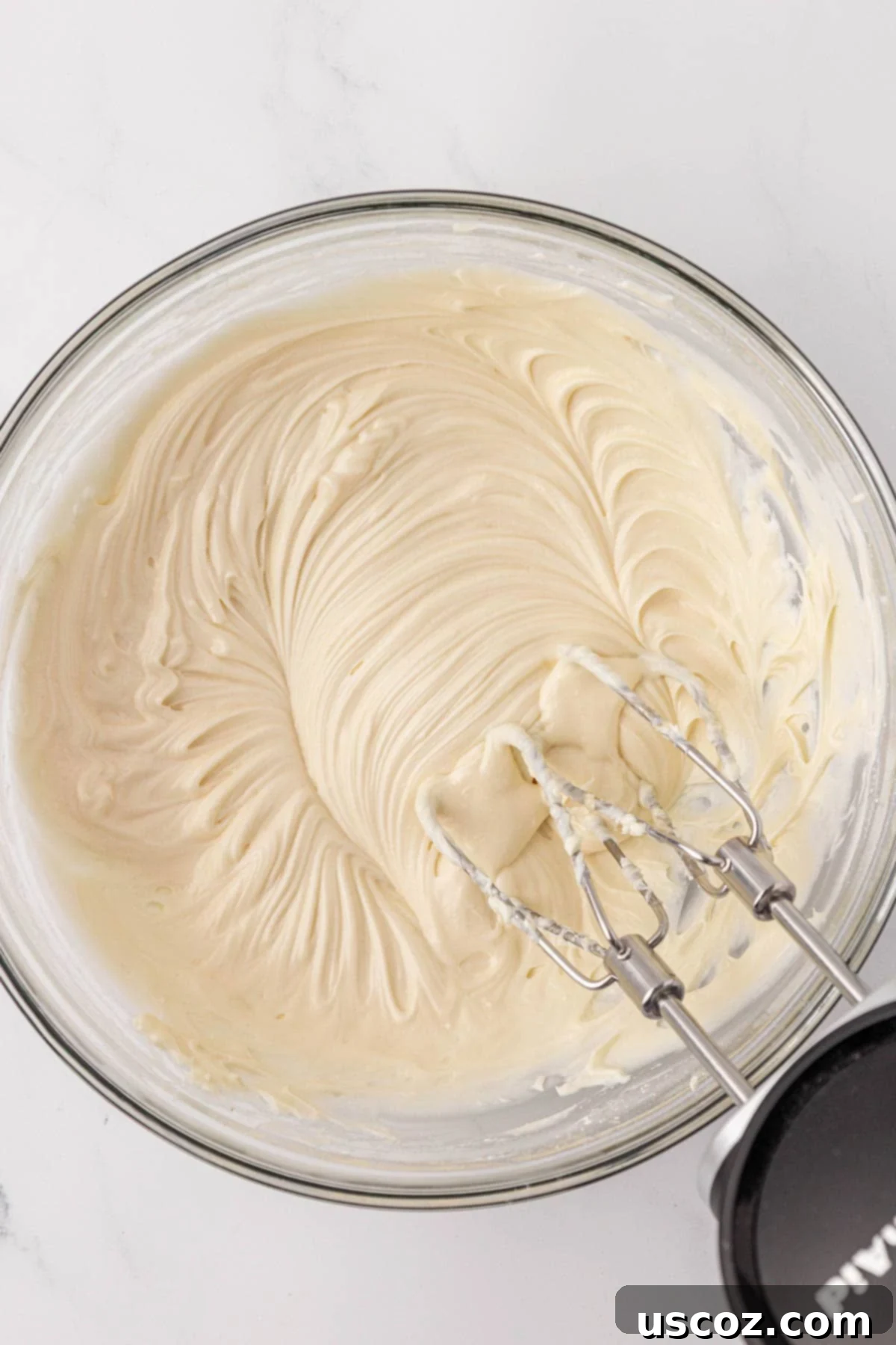 Smooth and creamy cream cheese frosting in a mixing bowl