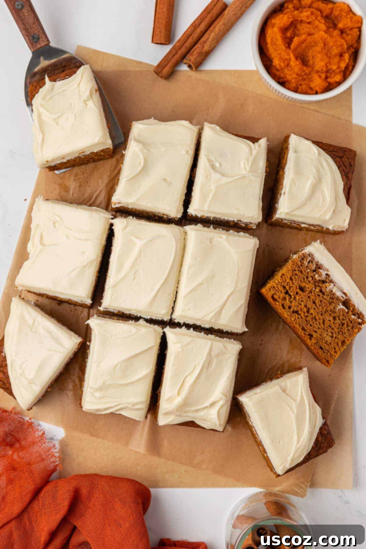 pumpkin snack cake cut into 12 squares on a cutting board