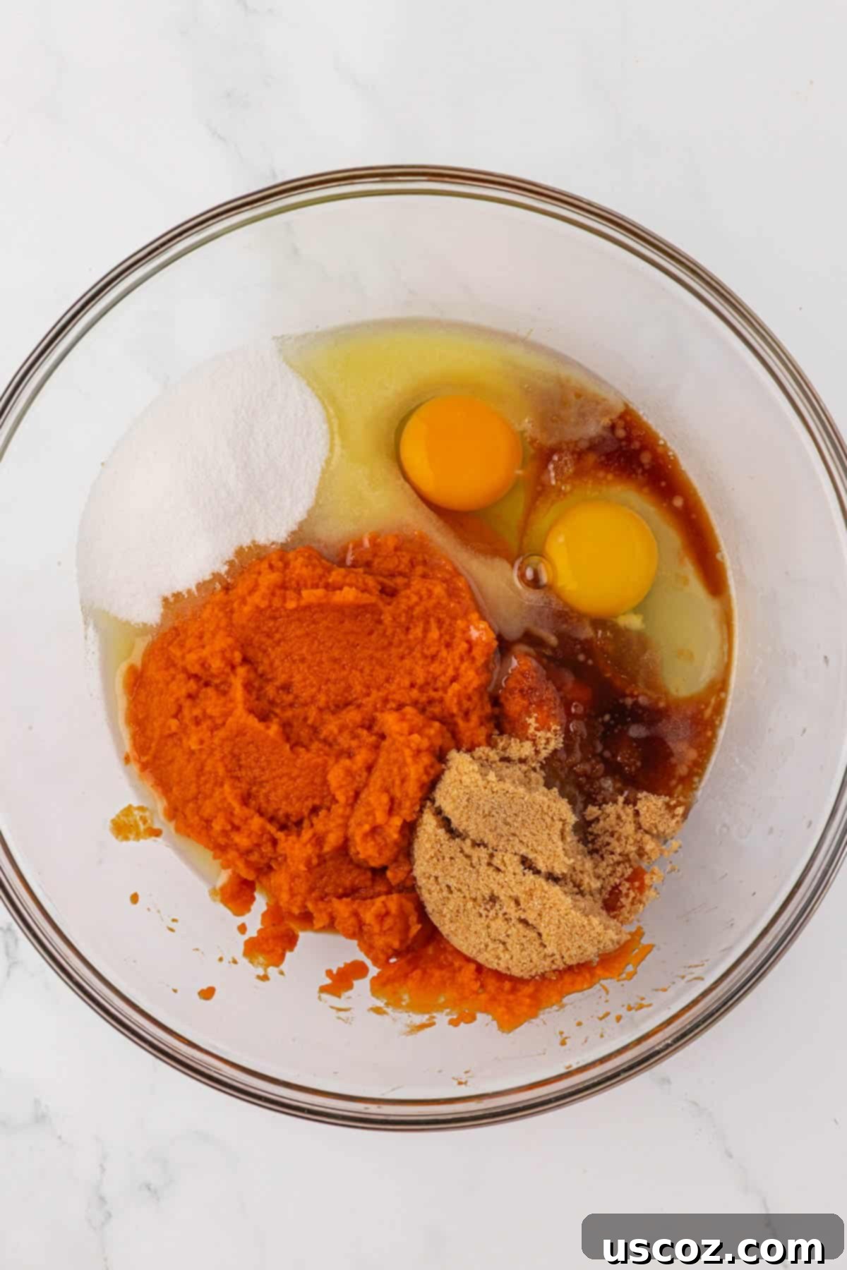 Wet ingredients for pumpkin snack cake in a mixing bowl before combining