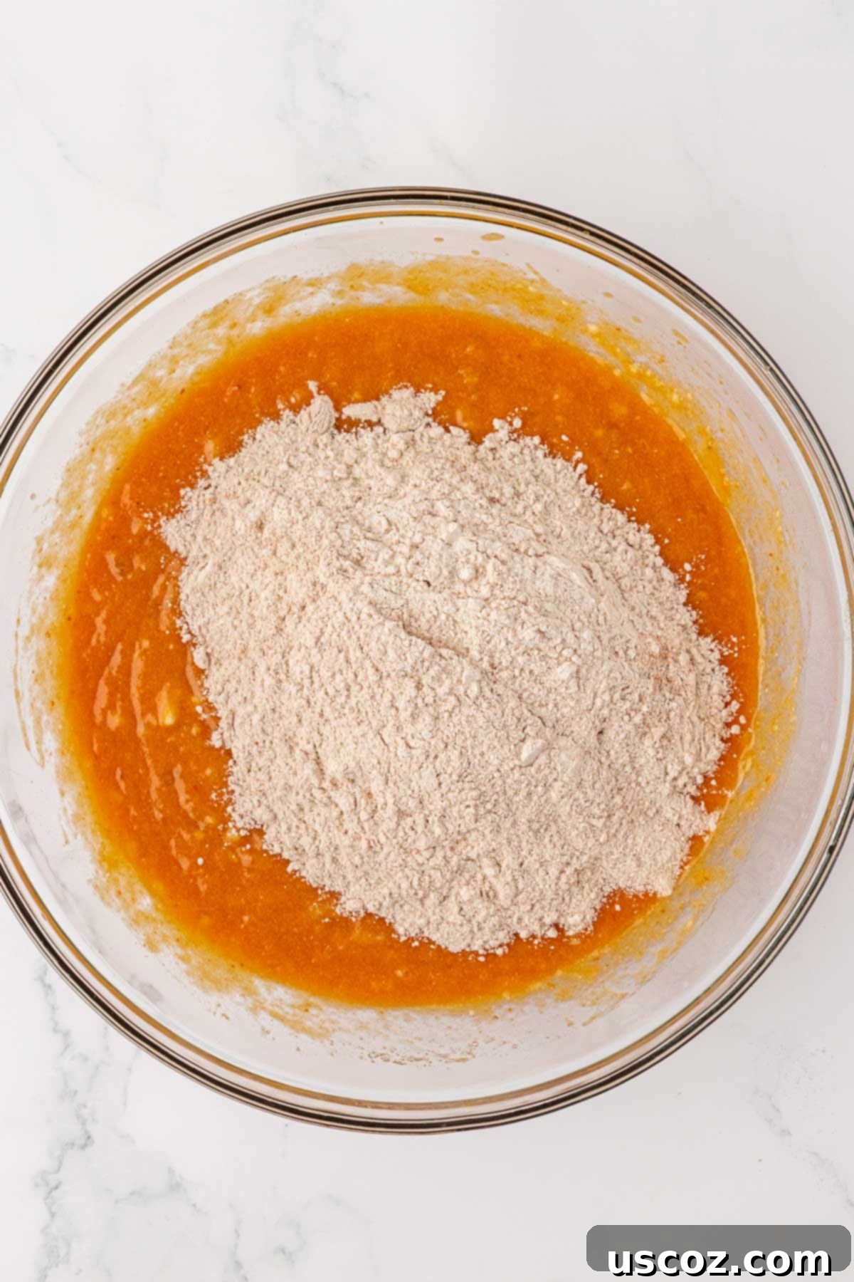 Golden Pumpkin Banana Muffins 11 adding the dry ingredients to the wet ingredients in a bowl