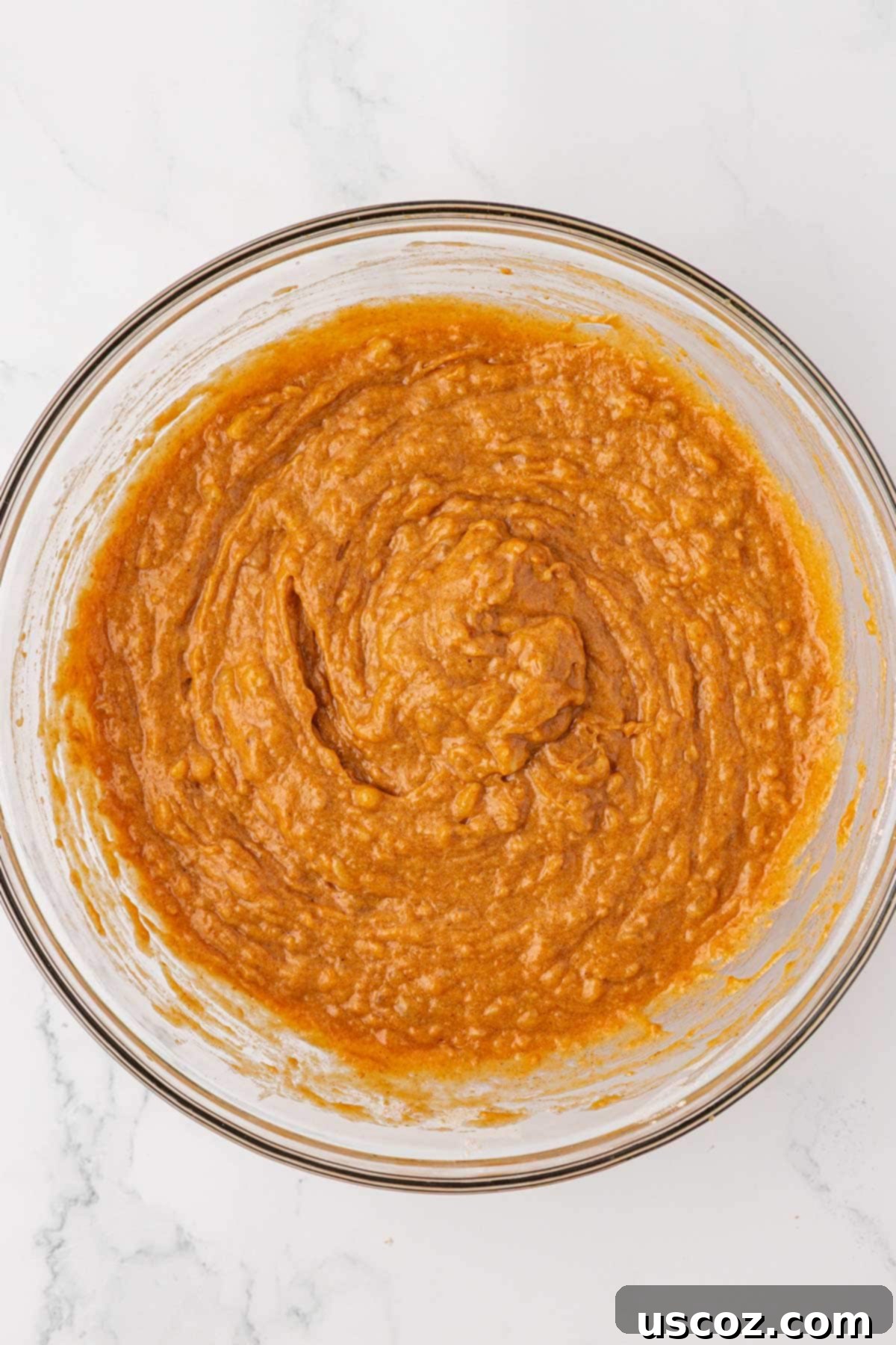 Golden Pumpkin Banana Muffins 12 pumpkin banana muffin batter mixed together with a rubber spatula