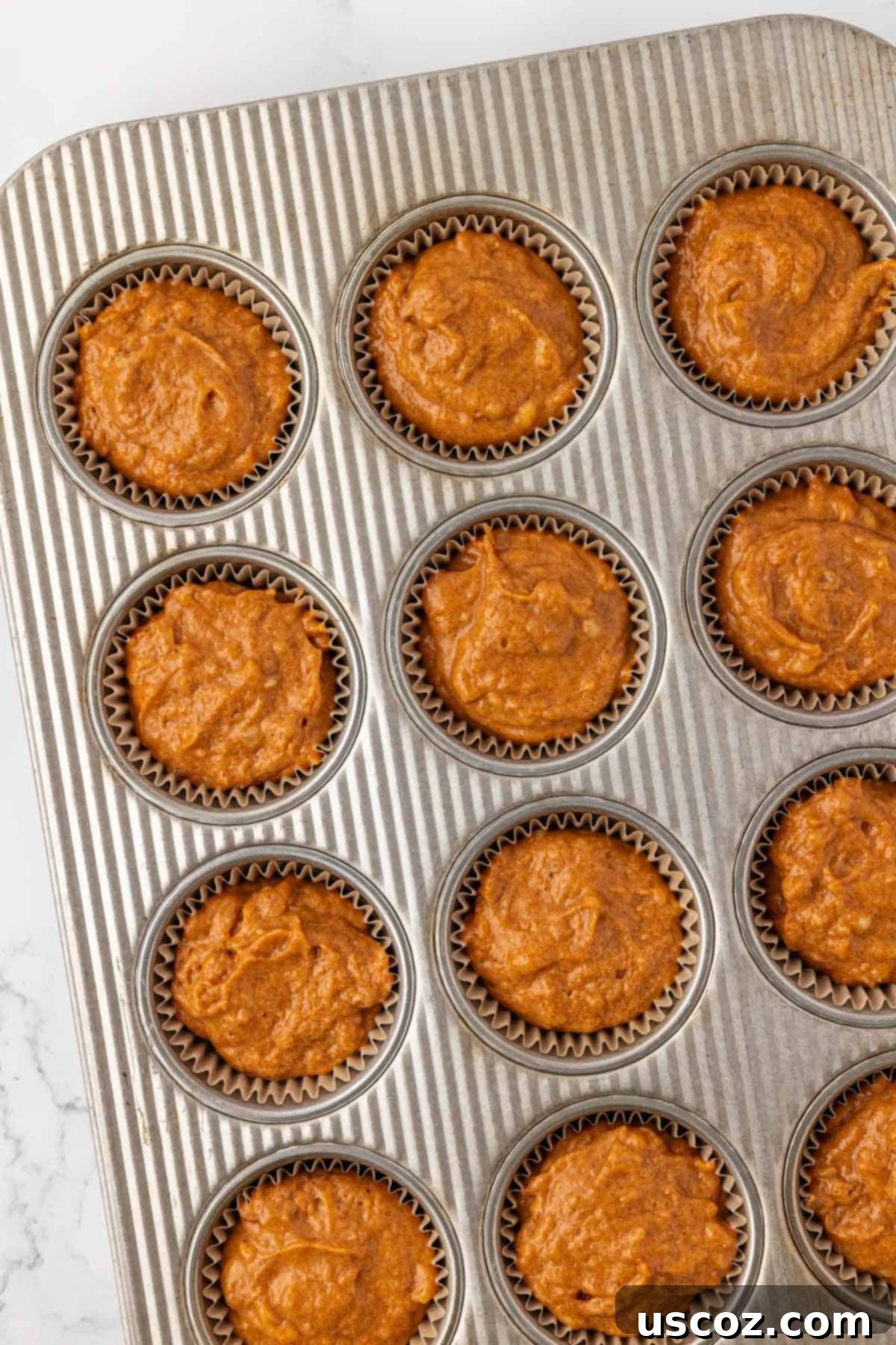 Golden Pumpkin Banana Muffins 14 muffin tin filled with pumpkin banana muffin batter