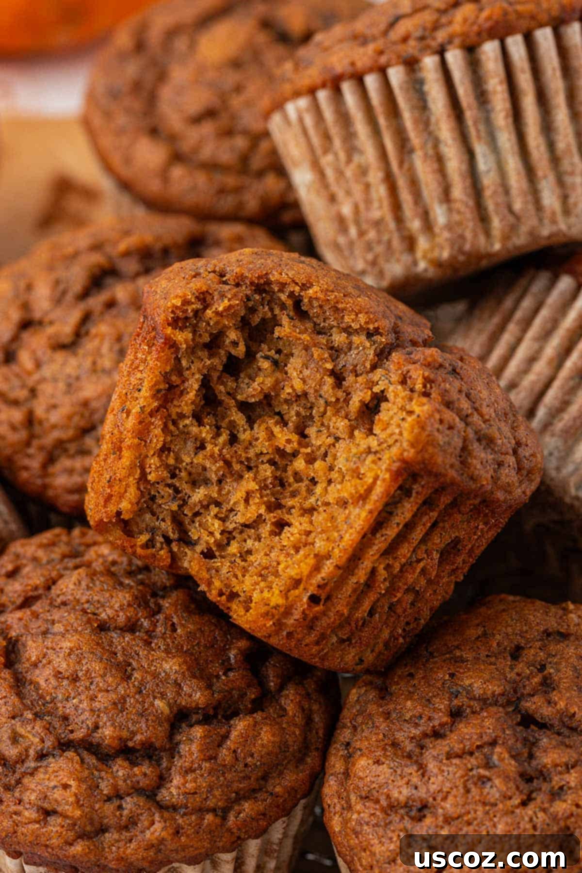 Golden Pumpkin Banana Muffins 18 a pumpkin banana muffin with a bite taken out, showing its moist interior