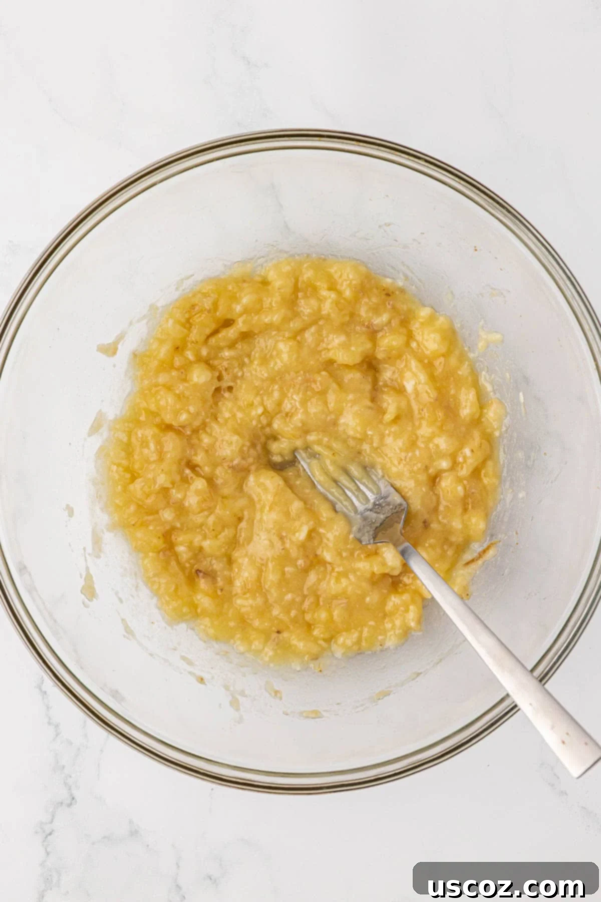 Golden Pumpkin Banana Muffins 8 mashed bananas with a fork in a mixing bowl