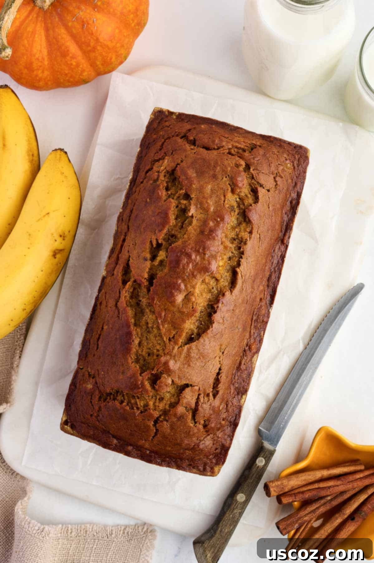 Close-up of a freshly baked loaf of pumpkin banana bread, still warm and ready to be sliced