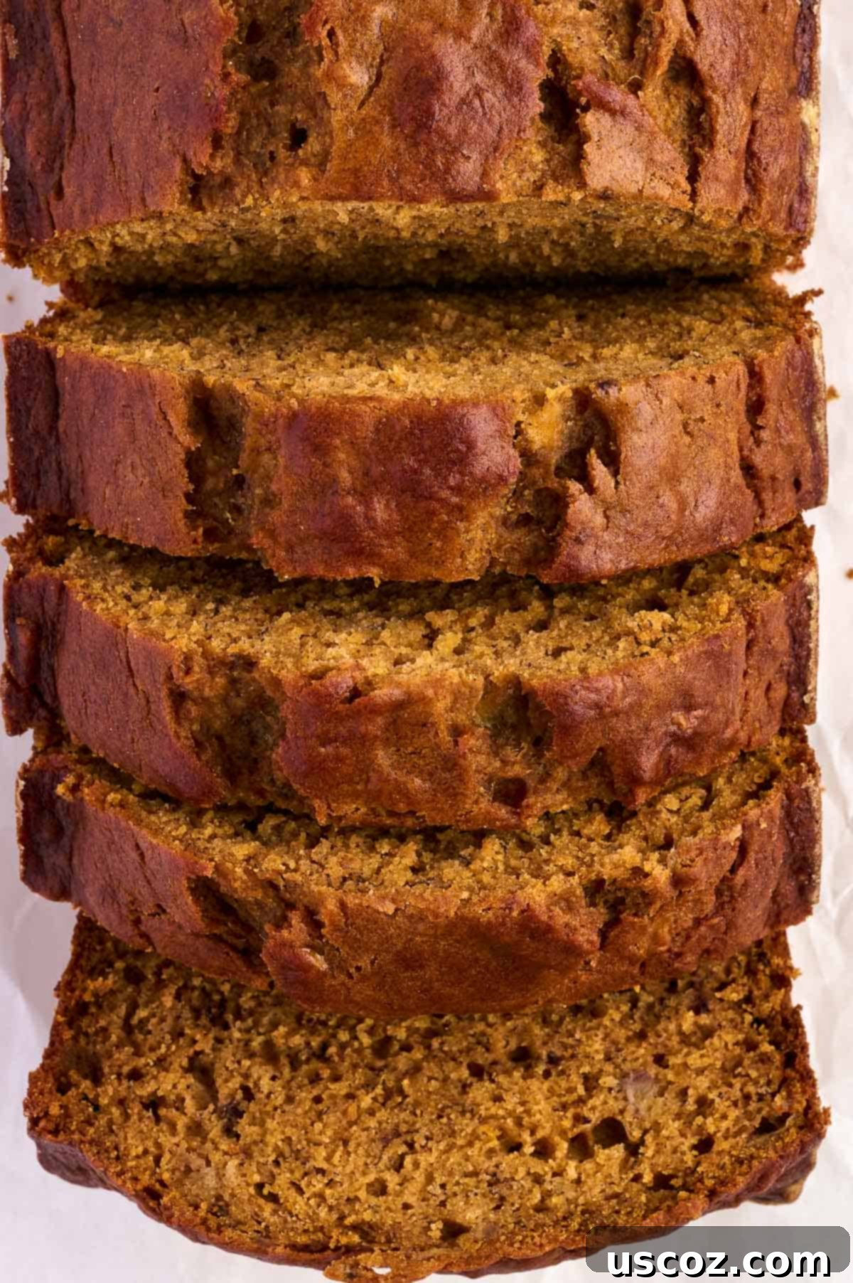 Slices of pumpkin banana bread on a cutting board, revealing the soft and tender interior