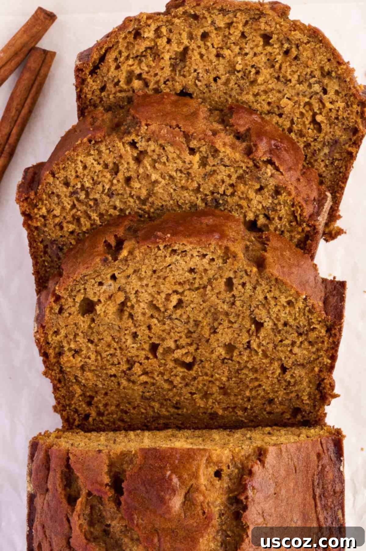 A stack of pumpkin banana bread slices, showcasing the beautiful color and inviting texture
