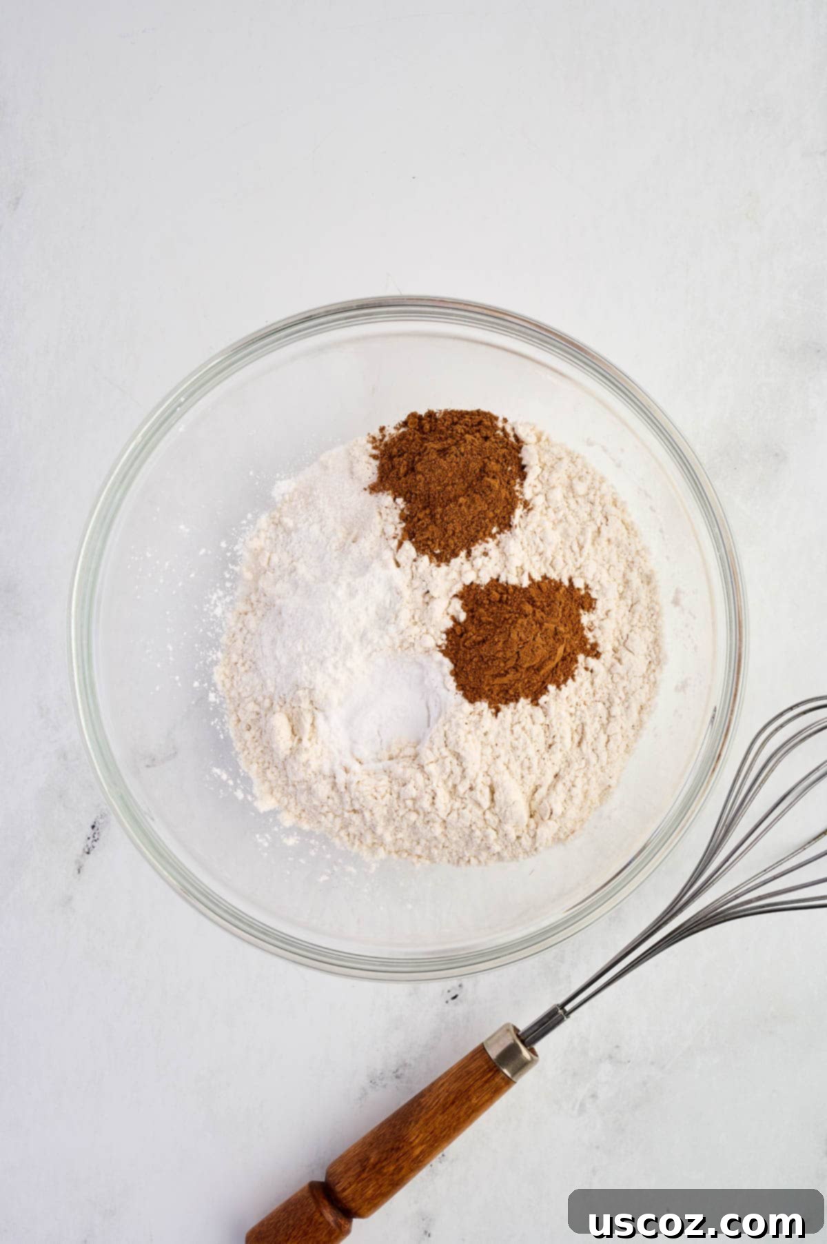 Dry ingredients (flour, spices, baking powder, baking soda, salt) in a mixing bowl before whisking